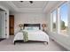 Bright bedroom with a tray ceiling, natural light from the windows, and a wooden door at 6371 Diamond Ridge Pkwy, Castle Rock, CO 80108