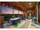 Covered patio boasts ample seating and dining areas with views of golf course at sunset at 6371 Diamond Ridge Pkwy, Castle Rock, CO 80108
