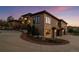 Exterior view of a luxurious home with stone accents and a paved driveway leading to the garages at 6371 Diamond Ridge Pkwy, Castle Rock, CO 80108