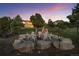 Picturesque backyard featuring a cozy fire pit area, set against a backdrop of mature trees at 6371 Diamond Ridge Pkwy, Castle Rock, CO 80108