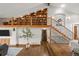 Spacious living room boasting high ceilings, a stone fireplace, hardwood floors, and custom bookshelves at 6371 Diamond Ridge Pkwy, Castle Rock, CO 80108