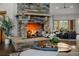 Cozy living room with a stone fireplace, comfortable seating, and natural light at 6371 Diamond Ridge Pkwy, Castle Rock, CO 80108