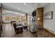 Open living area with stone fireplace, wood flooring and large windows providing natural light at 6371 Diamond Ridge Pkwy, Castle Rock, CO 80108