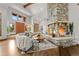 Open-concept living space with a stone fireplace, hardwood floors, and views of the entry and dining areas at 6371 Diamond Ridge Pkwy, Castle Rock, CO 80108