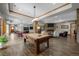 Spacious living room featuring a billiards table, stone fireplace and wood flooring at 6371 Diamond Ridge Pkwy, Castle Rock, CO 80108