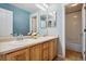Bathroom features a double vanity with wood cabinets and an adjoining shower at 10550 Sedalia St, Commerce City, CO 80022