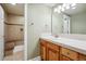 Well-lit bathroom features a tiled shower with a built-in bench and a wooden vanity at 10550 Sedalia St, Commerce City, CO 80022