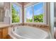 Close-up of a soaking tub under large windows, offering a spa-like experience with views of the outdoors at 10550 Sedalia St, Commerce City, CO 80022