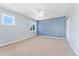 Spacious bedroom featuring neutral carpet, a ceiling fan, and two windows for natural light at 10550 Sedalia St, Commerce City, CO 80022