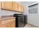 Well-lit laundry room features modern appliances and ample storage space, enhancing convenience for homeowners at 10550 Sedalia St, Commerce City, CO 80022