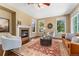 Bright living room with a cozy fireplace and three large windows at 10550 Sedalia St, Commerce City, CO 80022