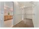Spacious walk-in closet with shelving, providing ample storage adjacent to the main bathroom and vanity area at 10550 Sedalia St, Commerce City, CO 80022