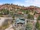 Nestled in a rocky, wooded area, this charming home boasts a green roof and a peaceful, secluded setting at 6584 Pike Cir, Larkspur, CO 80118