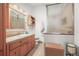 Well-lit bathroom featuring a vanity with wood cabinets, tile floor and enclosed glass walk-in shower at 6584 Pike Cir, Larkspur, CO 80118