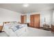Bedroom features neutral walls, wood flooring, and a spacious closet for storage at 6584 Pike Cir, Larkspur, CO 80118