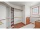 Walk-in closet providing ample storage space with adjustable shelving and laminate wood flooring at 6584 Pike Cir, Larkspur, CO 80118