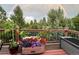 Charming wooden deck area with colorful flowers and a beautiful rainbow backdrop enhances the outdoor appeal at 6584 Pike Cir, Larkspur, CO 80118