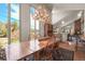 Open dining room with large windows and a statement antler chandelier, adjacent to a cozy living space with a fireplace at 6584 Pike Cir, Larkspur, CO 80118