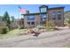 Inviting two-story home with a deck and lush landscaping. Front yard has american flag and stone features at 6584 Pike Cir, Larkspur, CO 80118