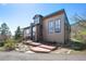 Beautifully landscaped home with a charming exterior and well-maintained grounds and wooden deck and walkways at 6584 Pike Cir, Larkspur, CO 80118