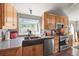 Gourmet kitchen with copper sink, stainless steel appliances, wooden cabinetry, and a bright window overlooking the yard at 6584 Pike Cir, Larkspur, CO 80118