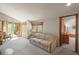 Bright living room featuring neutral carpet, a comfortable couch, and a door leading to a private deck or patio at 6584 Pike Cir, Larkspur, CO 80118