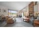 Cozy living room with a brick fireplace, large windows offering scenic views, and comfortable seating arrangement at 6584 Pike Cir, Larkspur, CO 80118