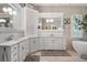 Bright bathroom featuring dual sinks, white cabinetry, a large mirror, and stylish decor at 4541 Tierra Alta Dr, Castle Rock, CO 80104