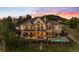 Dusk exterior of a home, highlighting pool, lighting, outdoor living space, and stone and stucco facade at 4541 Tierra Alta Dr, Castle Rock, CO 80104