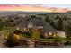 An impressive two-story home with a stone and stucco facade, tile roof, and a professionally landscaped front yard at sunset at 4541 Tierra Alta Dr, Castle Rock, CO 80104