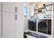 Neat laundry room with front-loading washer and dryer and custom cabinets at 4541 Tierra Alta Dr, Castle Rock, CO 80104