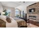 Cozy main bedroom with a stone fireplace, plush bedding, and plenty of natural light at 4541 Tierra Alta Dr, Castle Rock, CO 80104