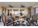 A luxurious patio area with seating around a fire pit, under a covered ceiling with fans at 4541 Tierra Alta Dr, Castle Rock, CO 80104