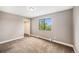 Neutral bedroom featuring soft carpet, closet, window with green tree views, and baseboard heating at 381 S Ames St # F204, Lakewood, CO 80226