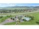 Scenic aerial view of community pool, parking area, surrounding neighborhood, and mountain views at 8307 S Garland Cir, Littleton, CO 80128