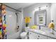 Bright bathroom featuring tiled shower-tub, granite counters, and updated fixtures at 8307 S Garland Cir, Littleton, CO 80128