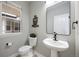 Powder room with modern fixtures, decorative mirror, and natural light from the window at 8307 S Garland Cir, Littleton, CO 80128