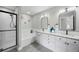 Bright bathroom featuring double vanity, granite countertops, and separate tub and tiled shower at 8307 S Garland Cir, Littleton, CO 80128