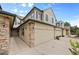 Two-story home featuring stone accents, neutral siding, and a two-car garage, under a bright blue sky at 8307 S Garland Cir, Littleton, CO 80128