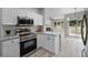 Modern kitchen with stainless steel appliances, granite countertops, and an open view to the living area at 8307 S Garland Cir, Littleton, CO 80128