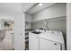 Convenient laundry room with modern washer and dryer, and ample shelving for storage at 8307 S Garland Cir, Littleton, CO 80128