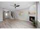 Bright living room featuring a modern fireplace, stairs and light wood flooring at 8307 S Garland Cir, Littleton, CO 80128