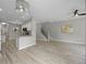 Bright living room flows into the kitchen, featuring stairs and light wood flooring at 8307 S Garland Cir, Littleton, CO 80128