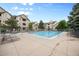 Community pool and hot tub are surrounded by lounge chairs, with a fence and nearby building at 8307 S Garland Cir, Littleton, CO 80128