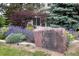 Community signage at Deer Creek Condominiums surrounded by landscaping and trees at 8307 S Garland Cir, Littleton, CO 80128