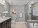 Modern bathroom featuring gray tile shower, soaker tub, and vanity with quartz countertop at 5716 Boston Ct, Denver, CO 80238
