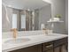 Bathroom featuring double vanity with gold fixtures and a large mirror reflecting the shower at 5716 Boston Ct, Denver, CO 80238