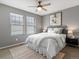 Comfortable bedroom with neutral tones, two windows, ceiling fan, and a decorative rug at 5716 Boston Ct, Denver, CO 80238
