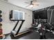 Well-equipped home gym featuring a treadmill, stationary bike, and weightlifting equipment on a black rubber floor at 5716 Boston Ct, Denver, CO 80238