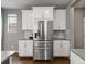 Modern kitchen featuring stainless steel refrigerator, white cabinets, and grey countertops at 5716 Boston Ct, Denver, CO 80238